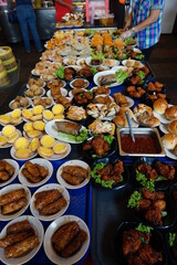 Traditional Chinese dim sum in metal bowl on wooden table. A lot of different kinds of food and drinks on the table