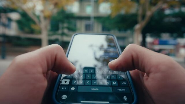 POV shot of man typing on smartphone keyboarn outduurs in city, close up shot