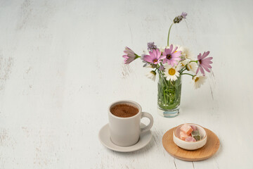 cup of Turkish coffee and delight on table with flowers