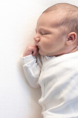 Sleeping newborn baby on white blanket. Beautiful portrait of little child.