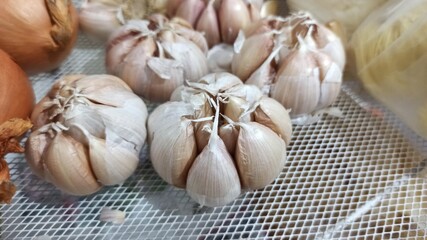Garlic and onion in plastic bag for sale at local market. Garlic in the market. Selective focus and shallow depth of field.