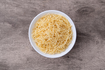 Potato straw or shoestring potato in a bowl over wooden table