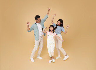 Portrait happy smiling Asian family fun hand up celebrate winner together isolated on nude color background.