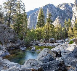 A stunning view of a calm pool of water surrounded by rugged rock formations at the bottom of...