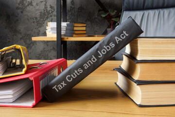 Book Tax Cuts and Jobs Act TCJA next to folders.