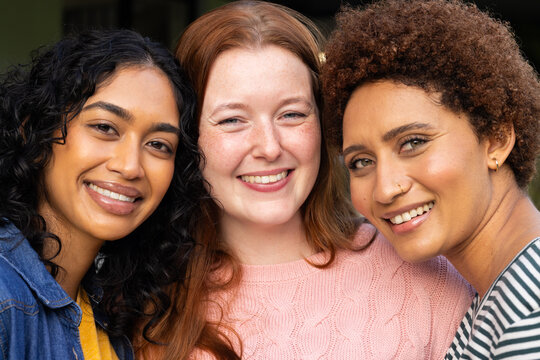 Smiling diverse women friends posing together, enjoying time and bonding outdoors