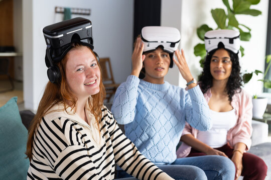Using VR headsets, diverse women friends enjoying virtual reality experience together