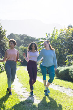 Walking outdoors, diverse women friends enjoying nature and bonding in park