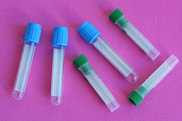 a set of clean different disposable plastic laboratory small test tubes with green and blue lids...
