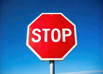 Obraz premium A bright red octagonal sign with white borders and bold black letters reading 