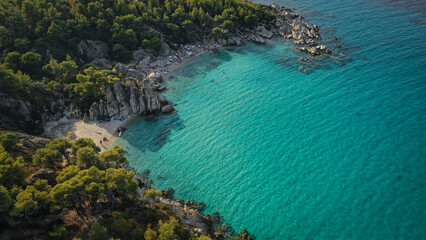 Obraz premium Paradise Found: A hidden beach cove where the turquoise waters meet the rugged cliffs, offering the perfect summer escape in Greece