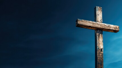 A rugged wooden cross rises against a deep blue twilight sky, symbolizing faith and spirituality. The contrast between the cross and backdrop highlights serenity and hope.