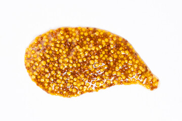 Smear of French Dijon mustard on a white background, top view
