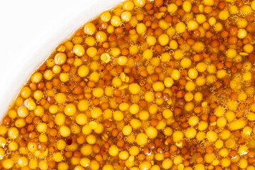 French Dijon mustard background, close-up, top view.