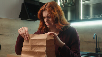 Shocked disgusted Caucasian hungry woman female client girl customer unpacking open paper bag order package sniff spoiled stink order bad smelling dish dislike smell feel nausea disgust indoor kitchen