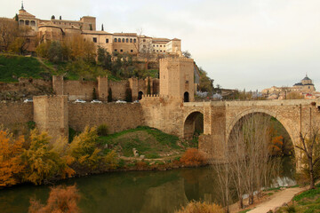 View of part of the historic part of the city with the Alcantara Bridge and Gate and the Tagus River in the foreground in the city of Toledo, near Madrid, Spain