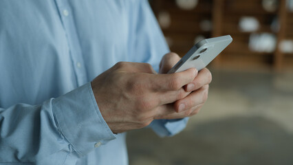 Side view unknown young Caucasian man businessman user male hands hold mobile cell phone typing message smartphone texting ordering delivery play game shopping online gadget use remote chat app indoor
