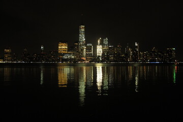 New York City skyline reflecting on the Hudson River at night