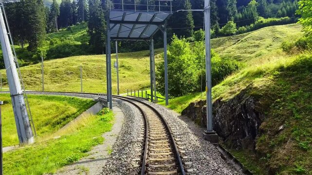 Rear View From the Glacier Express Train on Railroad Tracks in a Sunny Summer Day in Sedrun, Surselva, Oberalp, Grisons, Switzerland.