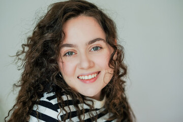 Portrait of young happy beautiful curly woman at home. Cozy.