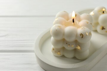 Stylish bubble candles on white wooden table, closeup. Space for text