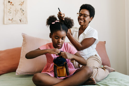 Caring for Afro hair: A loving moment between mother and daughter at home