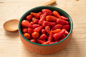 Bowl with pickled red mexican  peppers close up