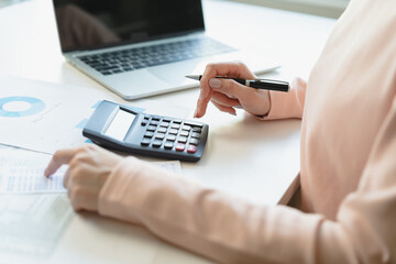 Deduction planning, debt asian young woman  hand using calculator to calculating money balance from bill and income, cost budget expenses for pay money form personal individual on table at home.