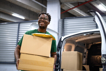 Professional courier loading his delivery truck with packages and parcels. Ready to deliver.
