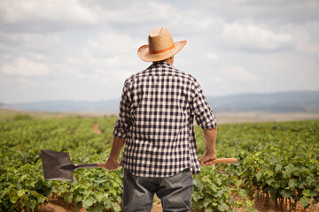 Rear view shot of a farmer with a shovel