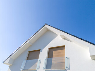 Modern house facade with balcony and closed shutters