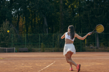 Obraz premium Young woman playing tennis outdoor at summer
