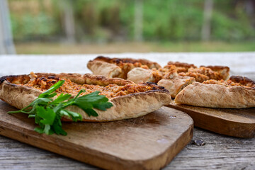  Traditional Turkish cuisine. Baked Pide dish with minced  beef, tomatoes and  herbs on  wooden background.  Turkish pizza pide