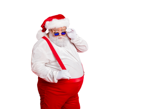 Portrait of handsome old funny fat overweight santa claus with big belly touch his retro specs choose naughty kids wear trousers pants isolated over red background