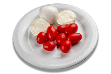 Whole and cut mozzarella cheese with cherry tomatoes in white plate cut out