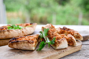  Traditional Turkish cuisine. Baked Pide dish with chicken ,  cheese and  herbs on  wooden background.  Turkish pizza pide