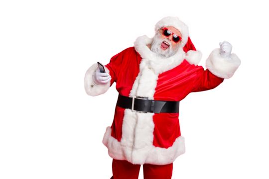Portrait of crazy santa claus in hat using cell phone device raising fists screaming yes having newyear party wearing belt eyewear eyeglasses isolated over red background