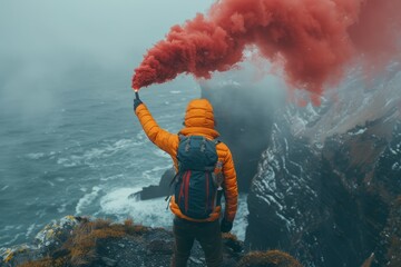 Distress signal  man in orange vest uses red smoke bomb on rocky island with gray clouds