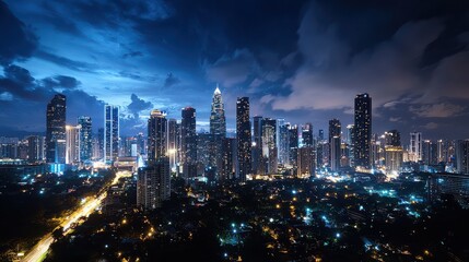 Fototapeta premium A city skyline at night with a cloudy sky. The city is lit up with lights and the sky is dark