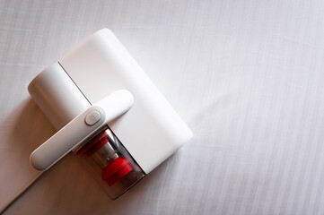 Vacuum cleaner for cleaning mattresses from mites with UV lamp and knocking out dust. Cleaning and disinfection of the mattress in the bedroom