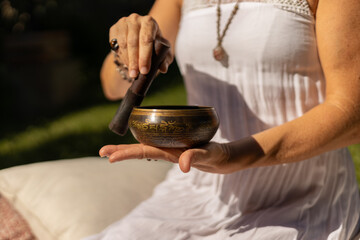 young woman playing a Tibetan singing bowl