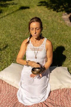 young woman playing a Tibetan singing bowl