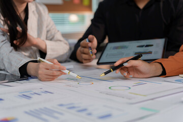 Business people are having a meeting and analyzing financial charts and graphs on the table using a digital tablet and documents
