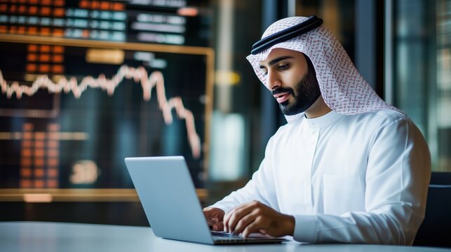 Professional man using laptop in modern office with stock market data displayed on screen during daytime in a financial district - Powered by Adobe
