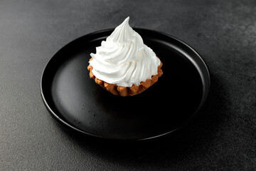 cake basket with protein cream in a black round plate on a black background