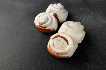 Fragrant Cinnabons with cream on a gray background