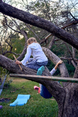 little sisters girls climb a tree, mother secures them below, camping with children