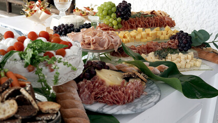 a beautiful table of cold cuts and cheeses at an elegant party
