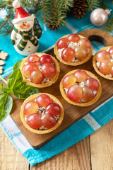 Creative appetizers christmas. Tartlets with chicken and grapes on the festive table on a rustic table.