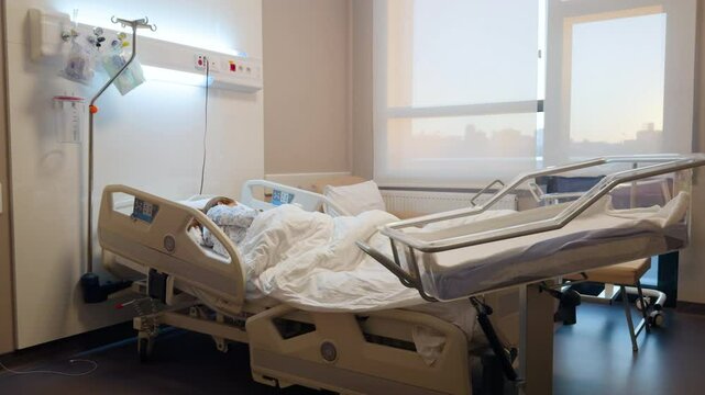 Woman breastfeeds her newborn lying on the bed after giving birth by caesarean section. Modern conditions in a private maternity hospital. Hospital room equipped with the most modern technologies